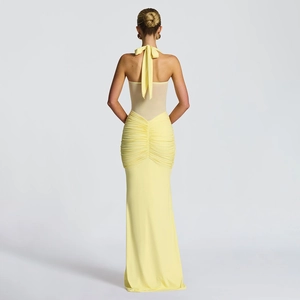 Detail view of the elegant backless design and ruched pleats on the yellow evening dress