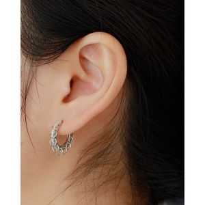 Close-up of S925 sterling silver hoop earrings with pave diamonds and small dangling rings