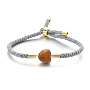 Adjustable woven bracelet featuring a heart-shaped tiger eye stone and gold metal accents