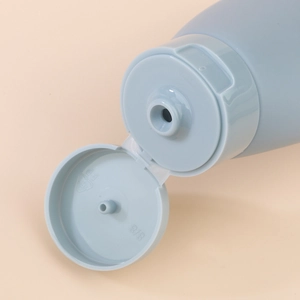 Light blue 60ml travel squeeze bottle with a flip-top cap showing the dispensing hole