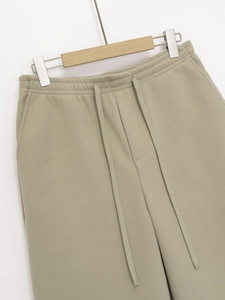 Detail of sage green joggers featuring soft brushed fabric and adjustable drawstring waist