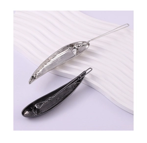Detailed view of silver and dark grey leaf hair clips with hammered lava texture finish