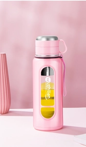 Pink portable glass water bottle with tea infuser and matte finish exterior on table