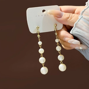 Elegant gold drop earrings with four white pearls on a long tassel chain, stylish jewelry