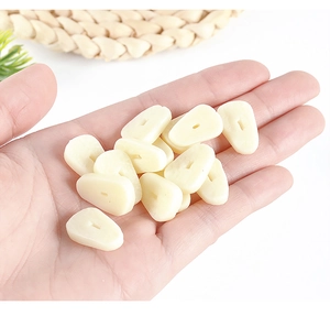 Macro shot of miniature PVC garlic clove charms with holes for DIY craft and food play