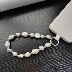 Bohemian marble bead phone strap with vintage silver pendant on dark wood background