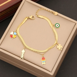 Dettaglio del bracciale a doppia catena dorata con ciondoli a forma di occhio