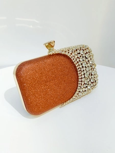 Detailed view of luxury orange sequin evening clutch with crystal wave and gold metal clasp