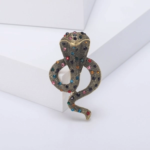 Detailed close-up of retro cobra snake brooch with colorful rhinestones and scales