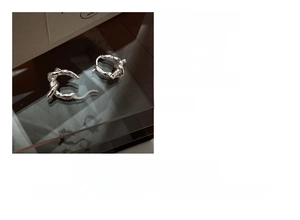 Detailed view of S925 sterling silver knotted earrings with textured metal finish