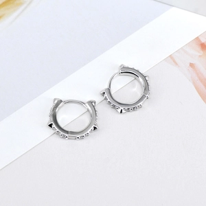 Macro shot of silver cat-ear huggie hoop earrings with micro-set rhinestones