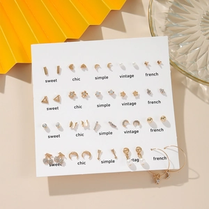 Detail of 20 pairs gold earring set featuring heart, pearl, and geometric stud designs