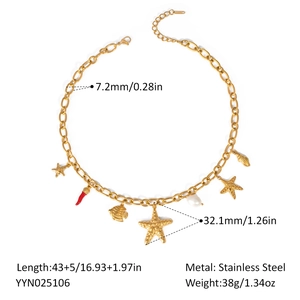 Detail of stainless steel necklace with ocean charms and red chili pendant on white base