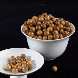 Artistic display of 8mm green sandalwood round beads in white ceramic bowls
