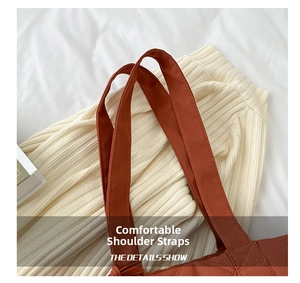 Close-up of quilted nylon tote bag with reinforced wide shoulder straps in terracotta