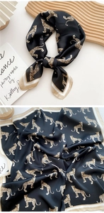 Detail of silk scarf showing leopard print pattern and elegant striped border detail