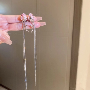 Detail of pink rose earrings with long tassel rhinestone chains held in hand