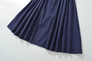 Detailed view of the dark blue pleated hem showing rich texture and fabric drape