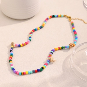 Detailed view of colorful seed beads and natural shells on an 18K gold plated necklace