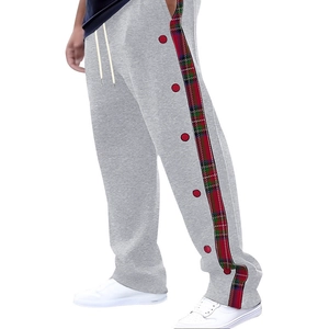 Detail of grey men's casual pants featuring red-green plaid side stripes and buttons