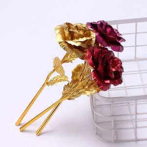 Close-up of golden and purple foil roses leaning on a white metal mesh basket