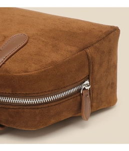 Detail of premium brown suede bowling bag featuring silver zipper and leather puller