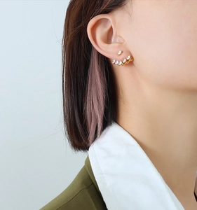 Close-up of gold ear jacket with cubic zirconia inlay on model wearing 18k gold earrings