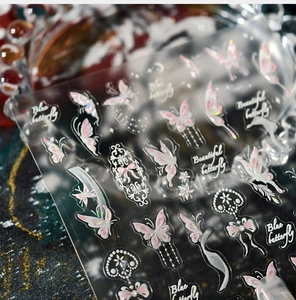 Macro detail of pink butterfly nail stickers with pearlescent finish and lace textures