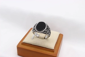 Detailed view of oval black gemstone on vintage silver ring with woven textures