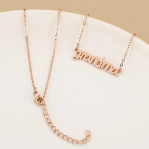 Detail of rose gold grandma pendant necklace with adjustable chain on a jewelry tray