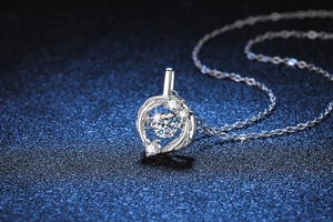 Macro detail of dancing Moissanite stone set in an S925 sterling silver feather pendant