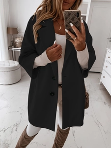 Détail d'une veste oversize noire en laine avec boutons et col à revers pour femme