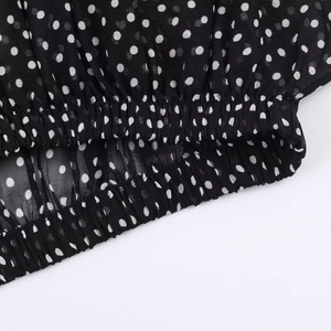 Dettaglio del tessuto in chiffon a pois bianchi e neri con vita elastica e cuciture fini