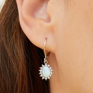 Silver oval opal halo earrings with sparkling cubic zirconia on a female model