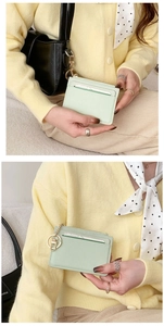 Detail of mint green card holder with gold keychain and vertical stripe texture