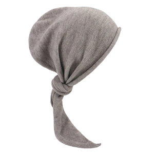 Close-up of light grey knitted beanie with elegant knot design and soft texture