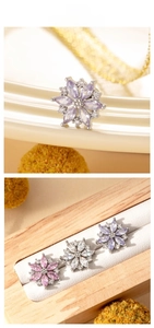 Macro detail of zircon flower earrings in titanium steel with purple and pink gemstone petals