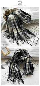Detail of black and white checkered scarf featuring soft fringe and classic plaid pattern
