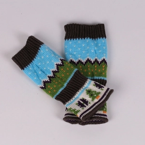 Close-up of knit arm warmer with colorful forest pattern and soft yarn texture
