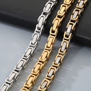 Macro shot of Byzantine weave stainless steel necklaces in silver, gold, and two-tone