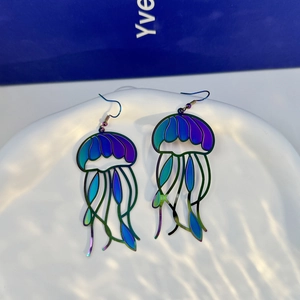 Macro detail of iridescent jellyfish earrings with laser-cut metallic finish and hooks