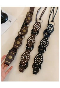 Detailed view of vintage leather belts with geometric hollow rings and bronze floral studs
