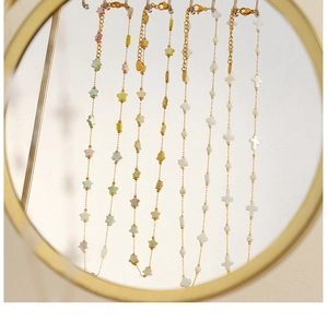 Detail of 18k gold plated titanium steel necklaces with colorful star and cross charms