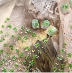 Detail of green four-leaf clover nail stickers with stars and grid patterns