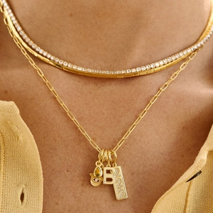 Close-up of layered 18K gold plated necklaces with birthstone and letter B pendant