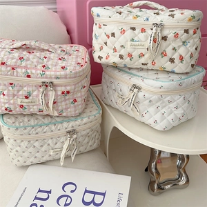 Detail of quilted floral cosmetic bags with bear and cherry prints and ribbon zippers