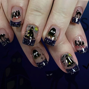 Short Halloween press-on nails with spooky cat, pumpkin, bats, and purple glitter