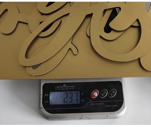 Mesure détaillée du poids de la décoration murale en métal doré affichant 237g sur balance