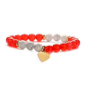 Close-up of agate beaded bracelet with white turquoise and a gold heart pendant