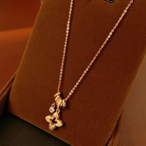 Golden four-leaf clover pendant necklace with hollow diamond-set rhombus and zircon crystals